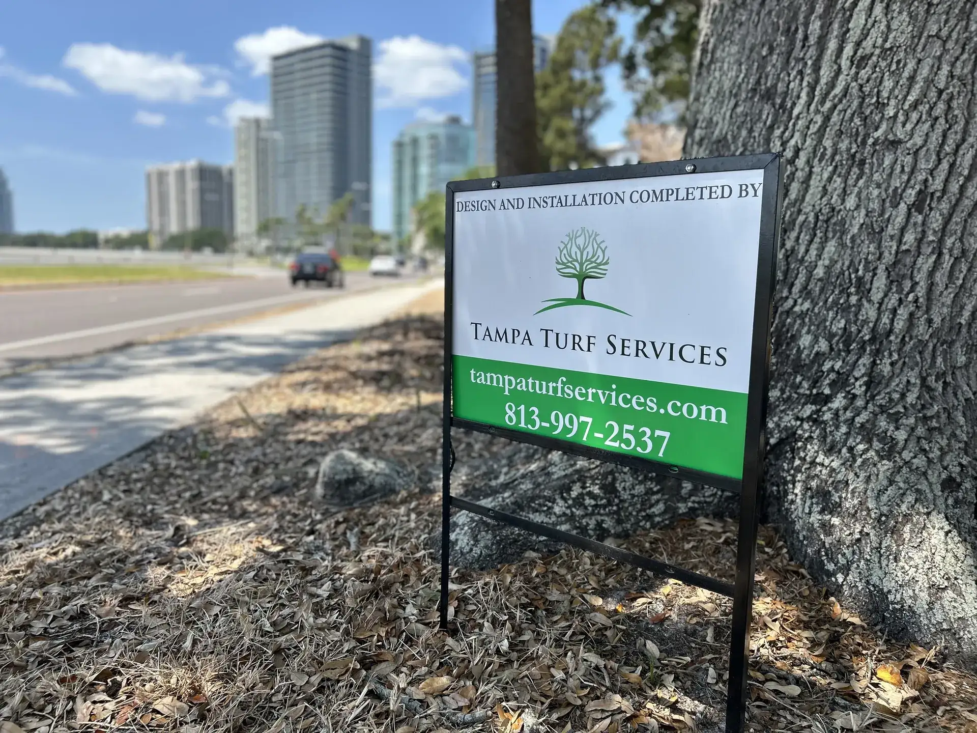 Tampa Turf Services yard sign with the downtown Tampa skyline behind it